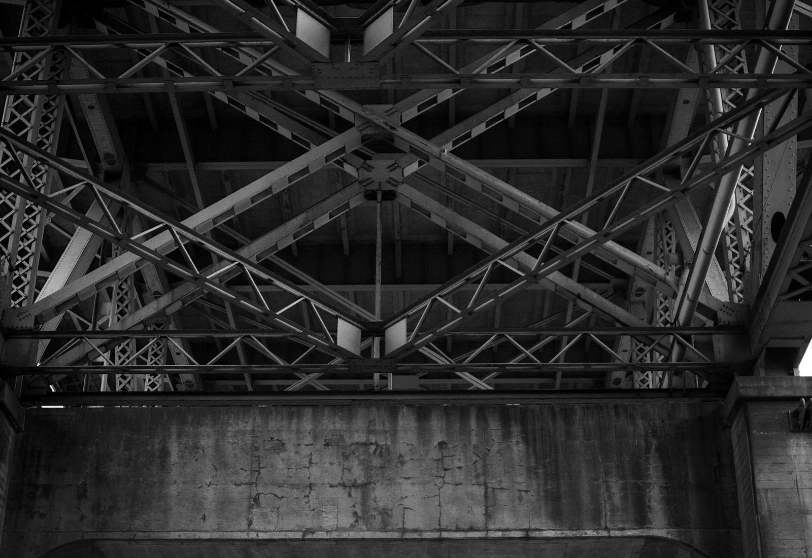 A dense steel lattice under a bridge deck