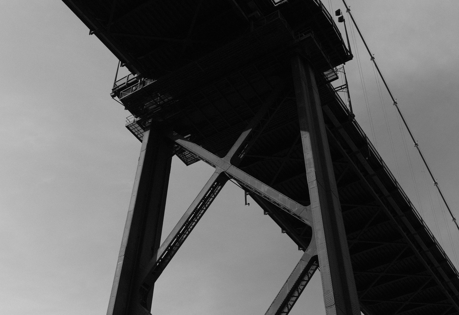 A suspension bridge tower and deck from below